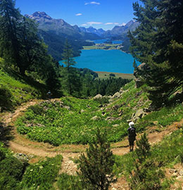 A hiker overlooks the lakes of Sils Maria, Switzerland during a hiking tour with Ryder-Walker Alpine Adventures.