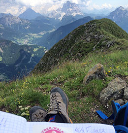 A hiker props up his feet with gorgeous views in the Italian Dolomites.