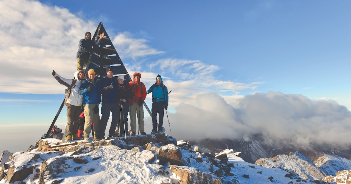 A group on the summit with fresh snow