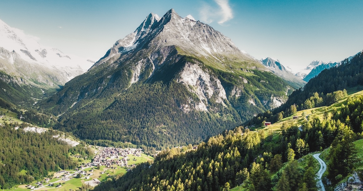 A large mountain with a tiny village in front