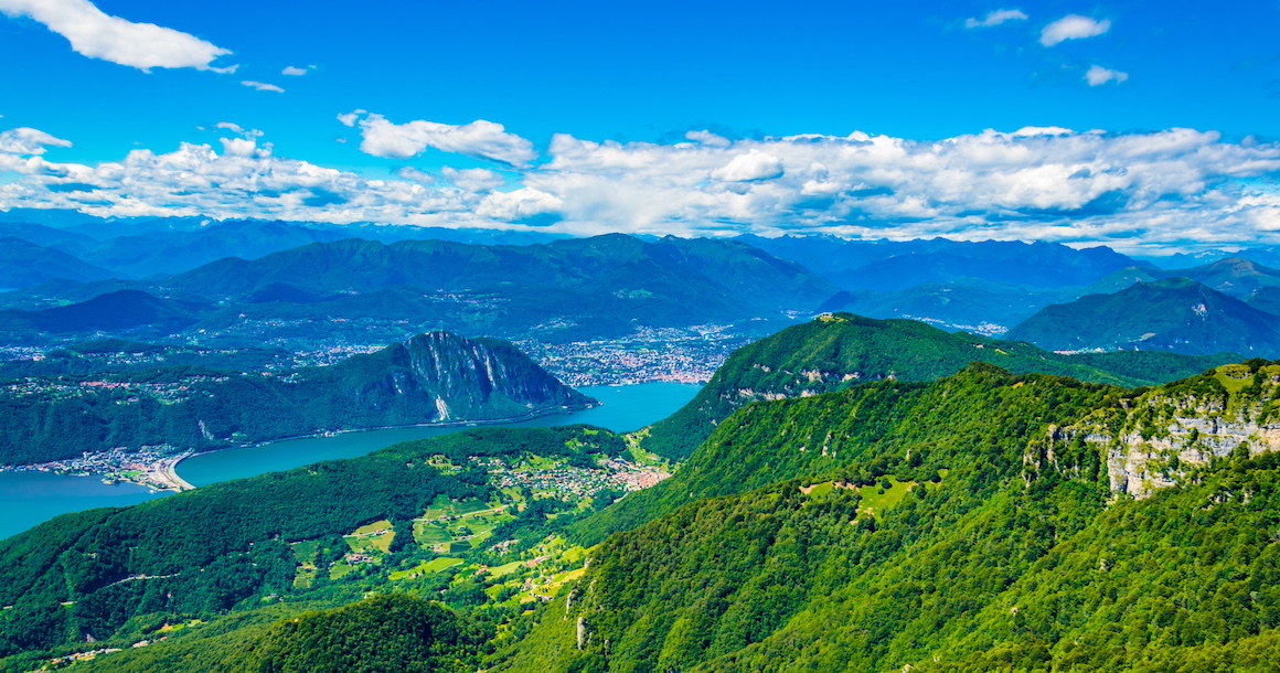 Aerial view of Lugano lake with green hills.