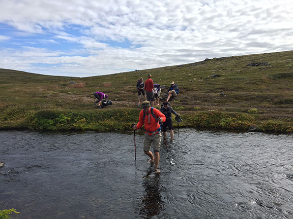 Crossing a stream while hiking in Iceland with Ryder-Walker Alpine Adventures.