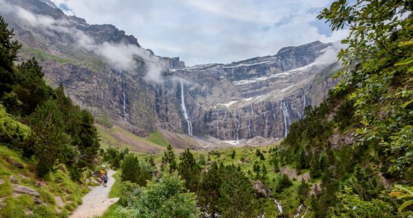 A stunning cirque with waterfalls and hikers taking in the view.