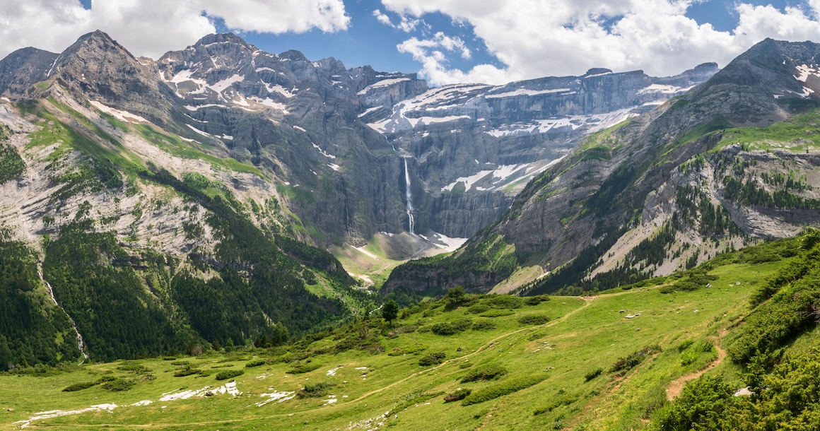 A beautiful valley with a waterfall on the cliff band.