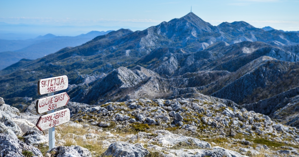 Biokovo mountain in Croatia with hiking signs in the foreground.