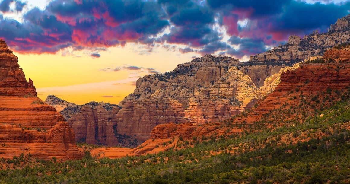 The sun sets against the red rocks