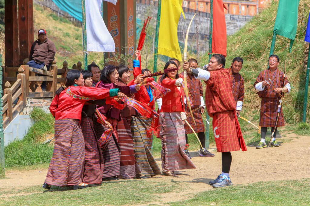 Men playing and archery competition in a public field in downtown Thimphu, Bhutan